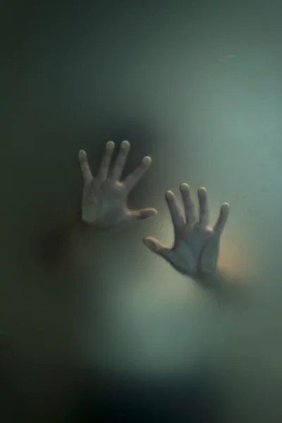 Silhouet van horror hand achter matglas — Stockfoto