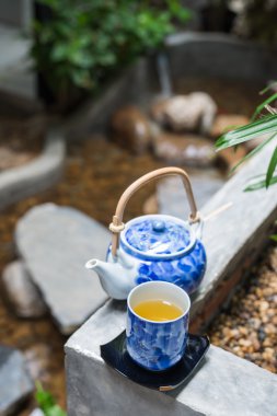 İçki serisi: Bahçedeki çay fincanı ve çaydanlığa yakın çekim