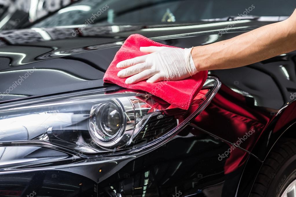 Car detailing series Worker cleaning black car — Stock Photo © 103202016