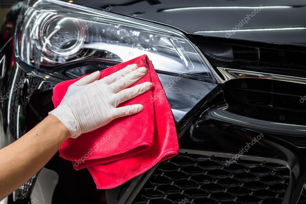 Car detailing series Worker cleaning black car Stock Photo by ©kunksy