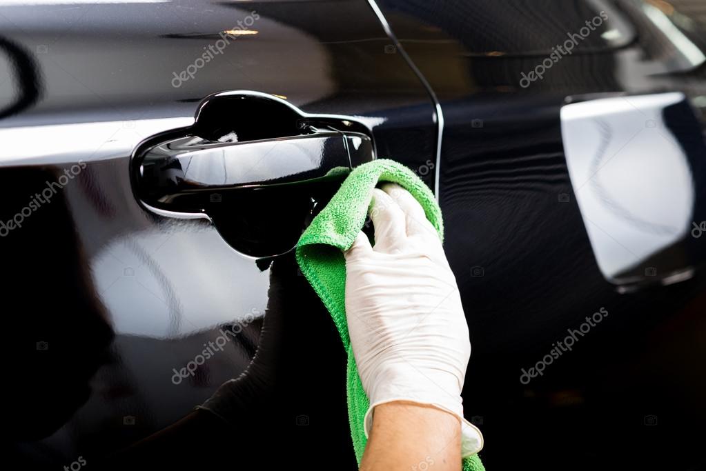 Car detailing series Worker cleaning black car Stock Photo by ©kunksy