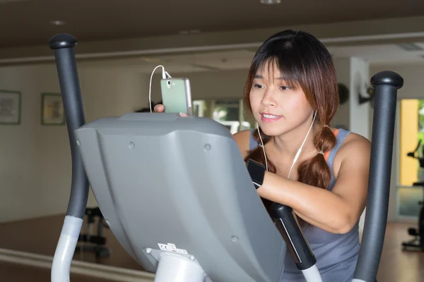 Série de exercícios: Ouvir música no elíptico — Fotografia de Stock