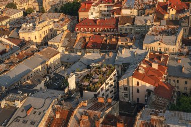 Altın saat ışığı, Avrupa 'nın fayanslı çatıları, kilise kuleleri, dar sokaklar ve aşağıdaki katmanlı kentsel dokulardan oluşan tarihi bir şehir manzarasını yıkıyor..