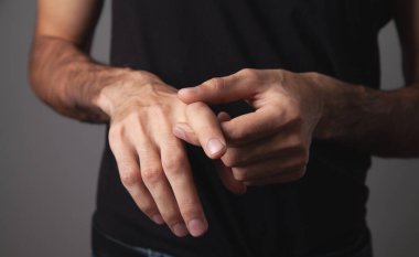 Adam ağrıyan parmağına masaj yapıyor., 