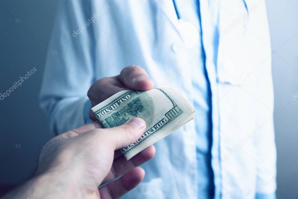 Doctor holding dollar bills close up