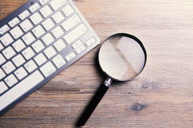 İnternet arama kavramı, büyüteç ve bilgisayar klavyesi