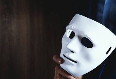 Elinde beyaz maske tutan bir iş adamı.