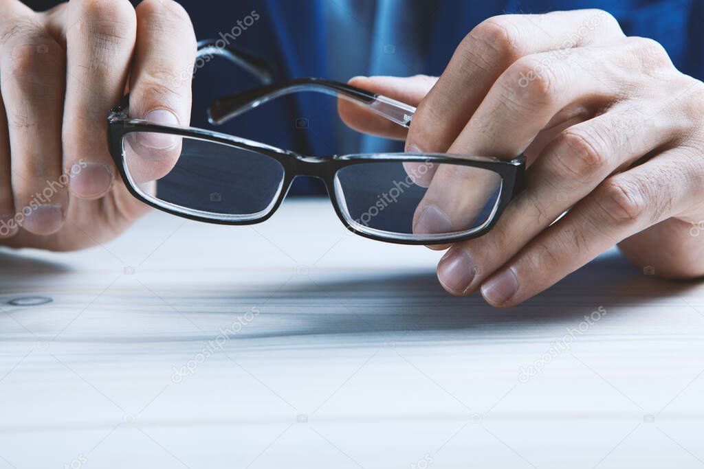 man holds glasses in his hands.