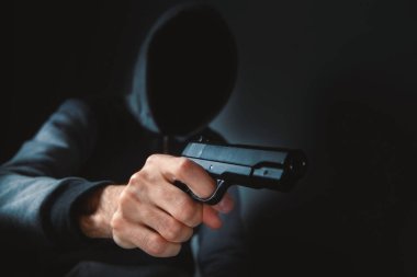 Adam elinde silah tutuyor ve tehdit ediyor.
