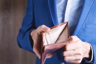 Genç adam boş cüzdan tutuyor.