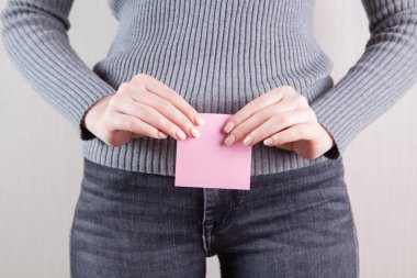 Kız elinde küçük bir kağıt gösteriyor.