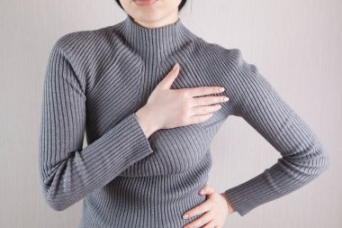 Ağır göğüs ağrısı çeken genç bir kadın.