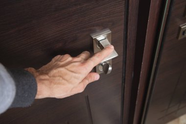 Genç adam yatak odasının kapısını açıyor.