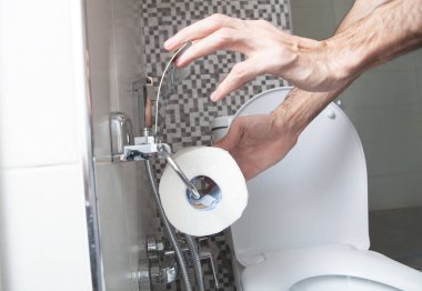 Elinde tuvalet kağıtları tutan adam..