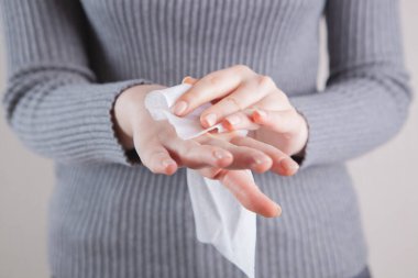 Kız ıslak peçeteyle ellerini temizliyor.