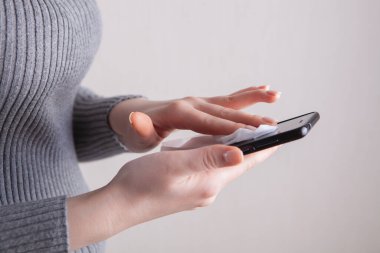 Kız telefon ekranını temizliyor.