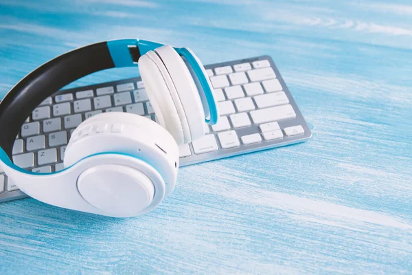 white headphones with computer listening to audio book or music