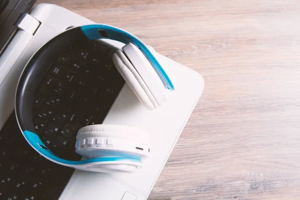 white headphones with computer listening to audio book or music