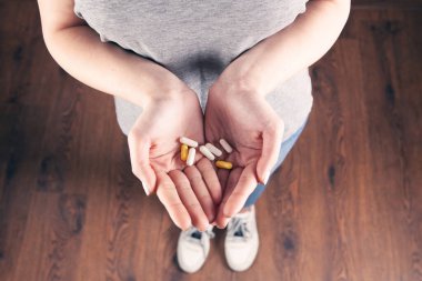 Yakın plan kadın el hapları tutuyor.