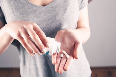 Yakın plan kadın el hapları tutuyor.