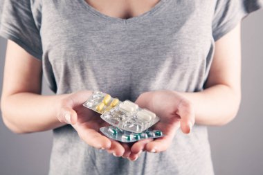 Yakın plan kadın el hapları tutuyor.