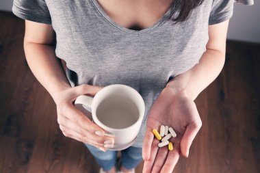 Yakın plan kadın el hapları tutuyor.