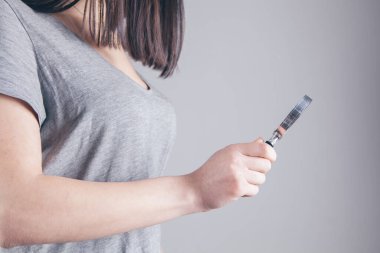 Kız elinde bir büyüteç tutuyor ve bakıyor.