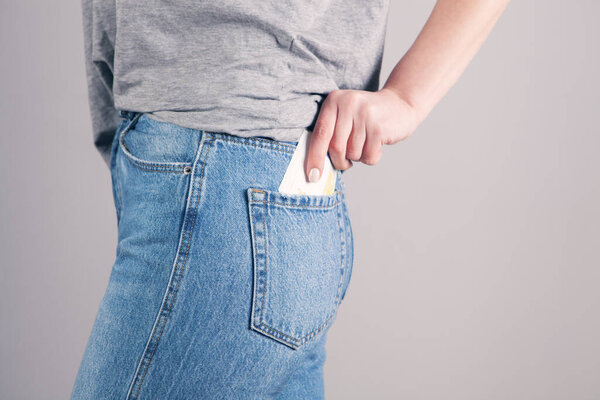 Девушка рука положить деньги в карман джинсы