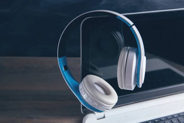 white headphones with computer listening to audio book or music