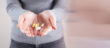 Elinde haplar tutan bir kız.