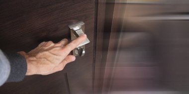 Genç adam yatak odasının kapısını açıyor.