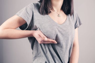 Kız ellerini göğsüne bastırıyor.