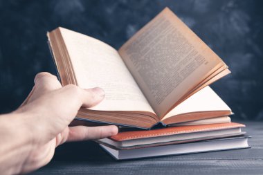 Elinde kitap tutan bir adam.