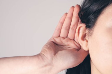 Kız dikkatle diğer insanların konuşmalarına kulak misafiri oluyor.