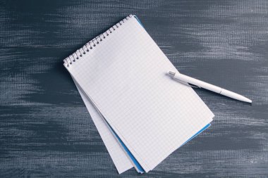 Masanın üzerinde kalemler olan bir defter.