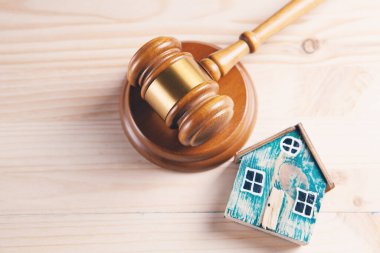 Yargıç Tokmak ve ahşap bir arka planda evler. Gayrimenkul müzayedesi ya da boşanma durumunda bir evin bölümü kavramı.