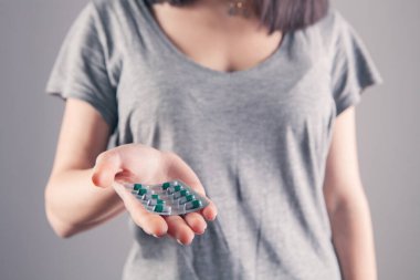 Yakın plan kadın el hapları tutuyor.