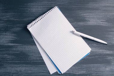 Masanın üzerinde kalemler olan bir defter.