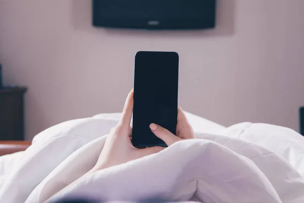 Flickan Ligger Sängen Och Använder Telefonen — Stockfoto