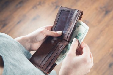 Kız cüzdanı elinde tutuyor ve parayı alıyor.