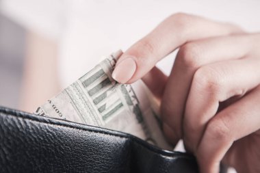 Kız cüzdanı elinde tutuyor ve parayı alıyor.