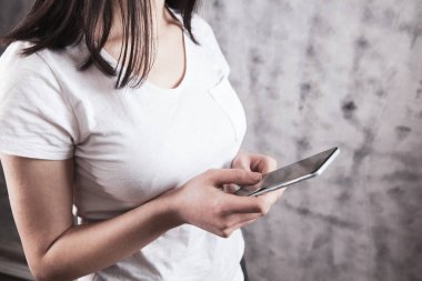 Elinde telefon tutan genç bir kız.