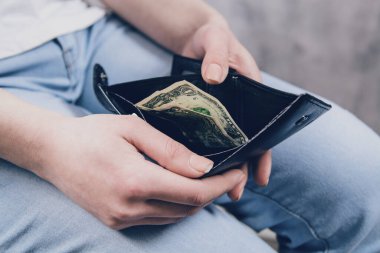 Kız cüzdanı elinde tutuyor ve parayı alıyor.