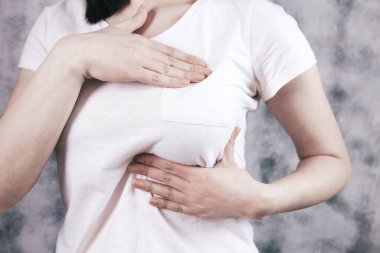 Kız ellerini göğsüne bastırıyor.