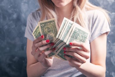 Elinde büyük para tutan bir kız.