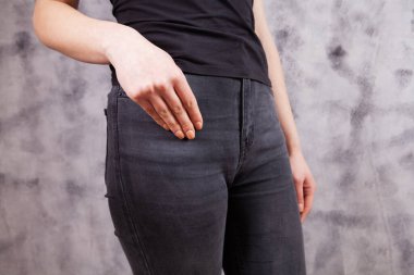 Gri arka planda koyu renk kot giyen bir kadın