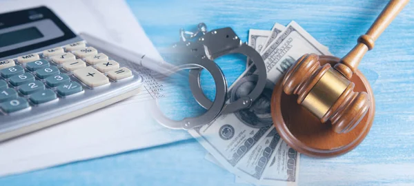 Financial fraud concept, judge gavel, calculators and handcuffs on financial documents