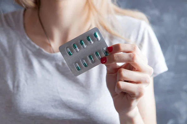 Mujer Joven Sosteniendo Píldoras Sobre Fondo Gris — Foto de Stock