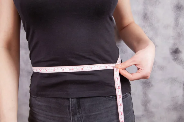 Niña Mide Circunferencia Abdominal Sobre Fondo Gris — Foto de Stock