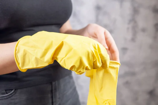 Young Woman Puts Yellow Rubber Gloves Gray Background — Stock Photo, Image